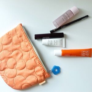 Orange Quilted Makeup Bag with Skincare and Beauty Products